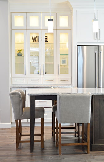 Modern white kitchen with glass cabinets and island seating