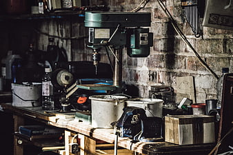 Cluttered workshop bench with drill press and tools