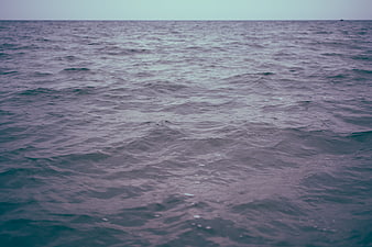 Calm ocean surface with gentle waves and moody purple tones