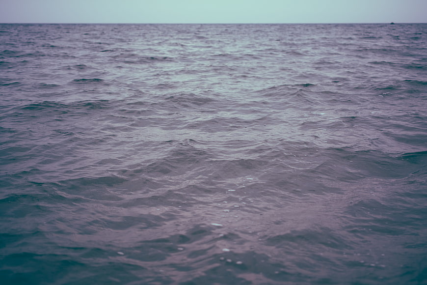 Calm ocean surface with gentle waves and moody purple tones