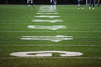 Low angle view of football field yard lines and players
