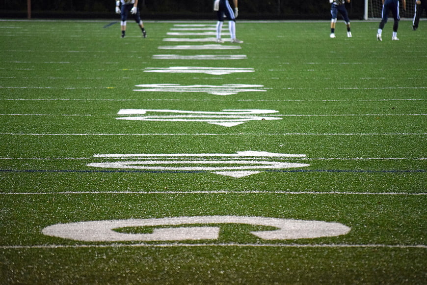 Low angle view of football field yard lines and players