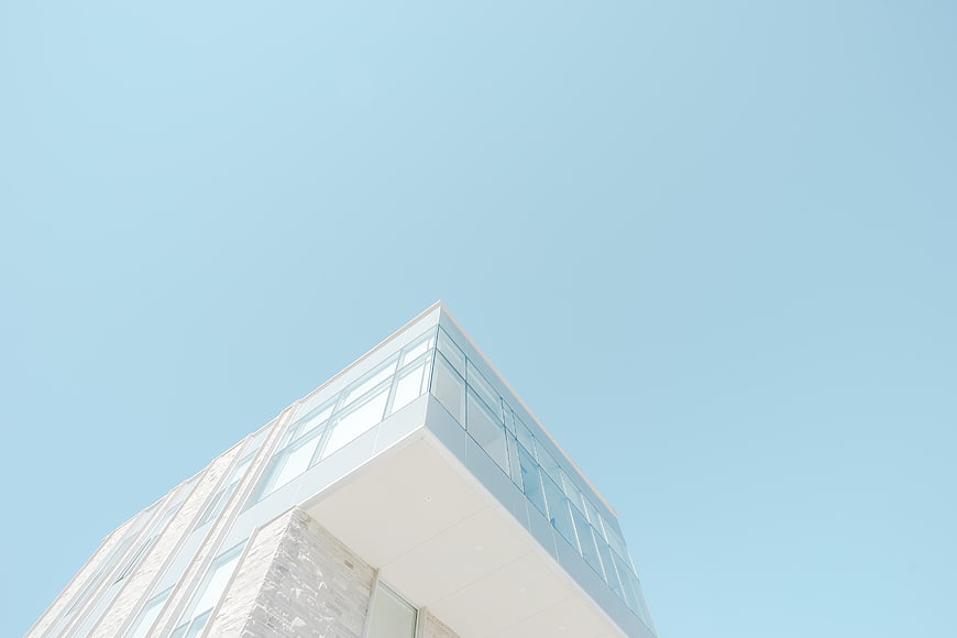Modern white building corner against clear blue sky