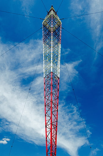 Low Angle View of Red and White Radio Antenna Tower Against Blue Sky