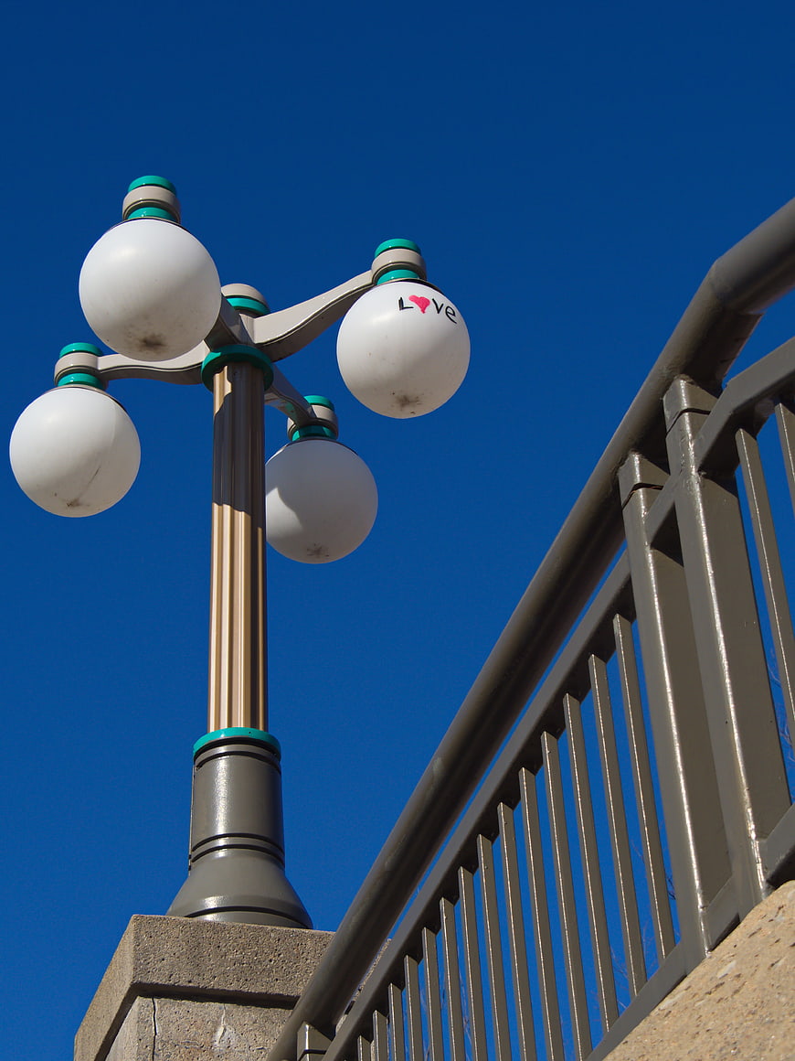 White Globe Street Lamp with Love Text on Blue Sky