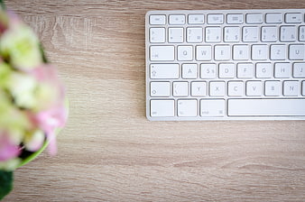 White Keyboard on Wooden Desk with Pink Flowers