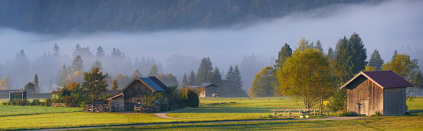 Misty Autumn Morning in Bavarian Countryside with Barns