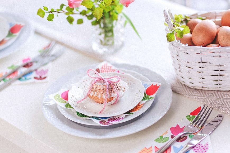 Easter table setting with muffin, eggs, and floral napkins