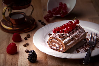 Chocolate Swiss Roll Cake With Red Currants And Berries On Wooden Table