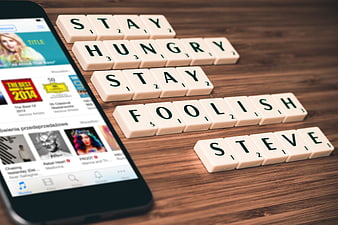 Scrabble tiles spelling Steve Jobs quotes next to smartphone