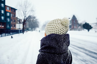 Person in Knit Beanie Looking at Snowy City Street