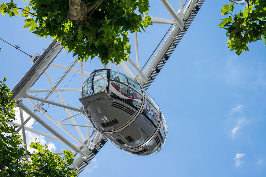 Low angle view of London Eye capsule against blue sky