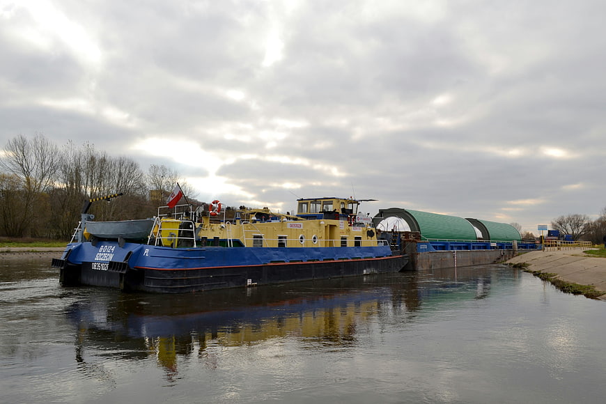 Blue and yellow cargo barge on a river