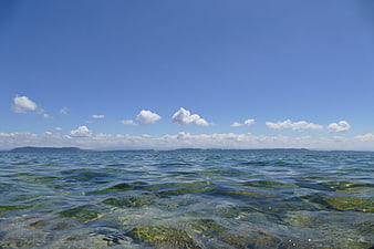 Clear Blue Sea Water with Distant Coastline and Clouds