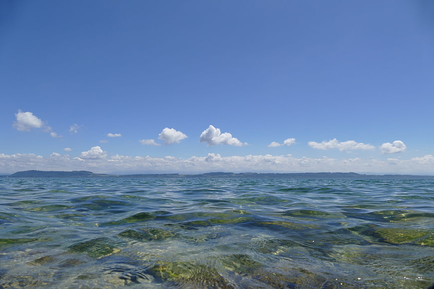 Clear Blue Sea Water with Distant Coastline and Clouds