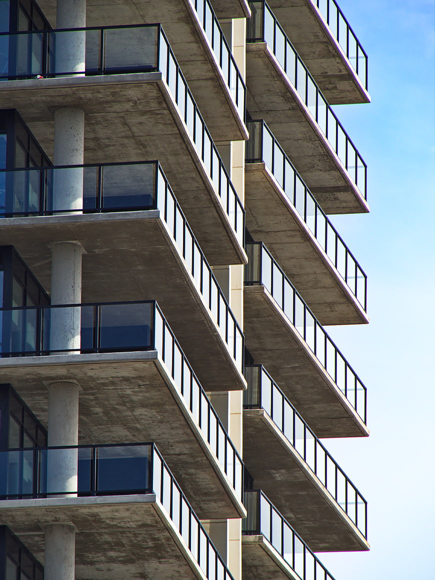 Modern Concrete Apartment Building Balconies Against Blue Sky