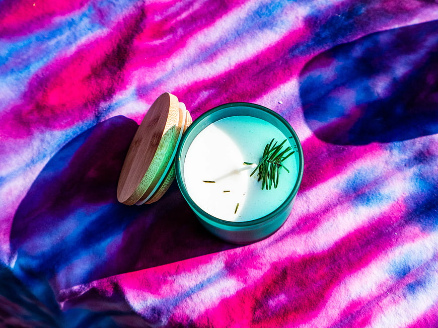 Scented Candle with Rosemary on Vibrant Tie-Dye Fabric