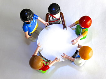 Playmobil figures meeting around a white round table