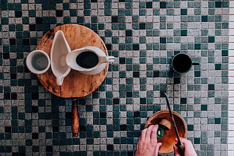 Top view of coffee and kiwi on tiled table