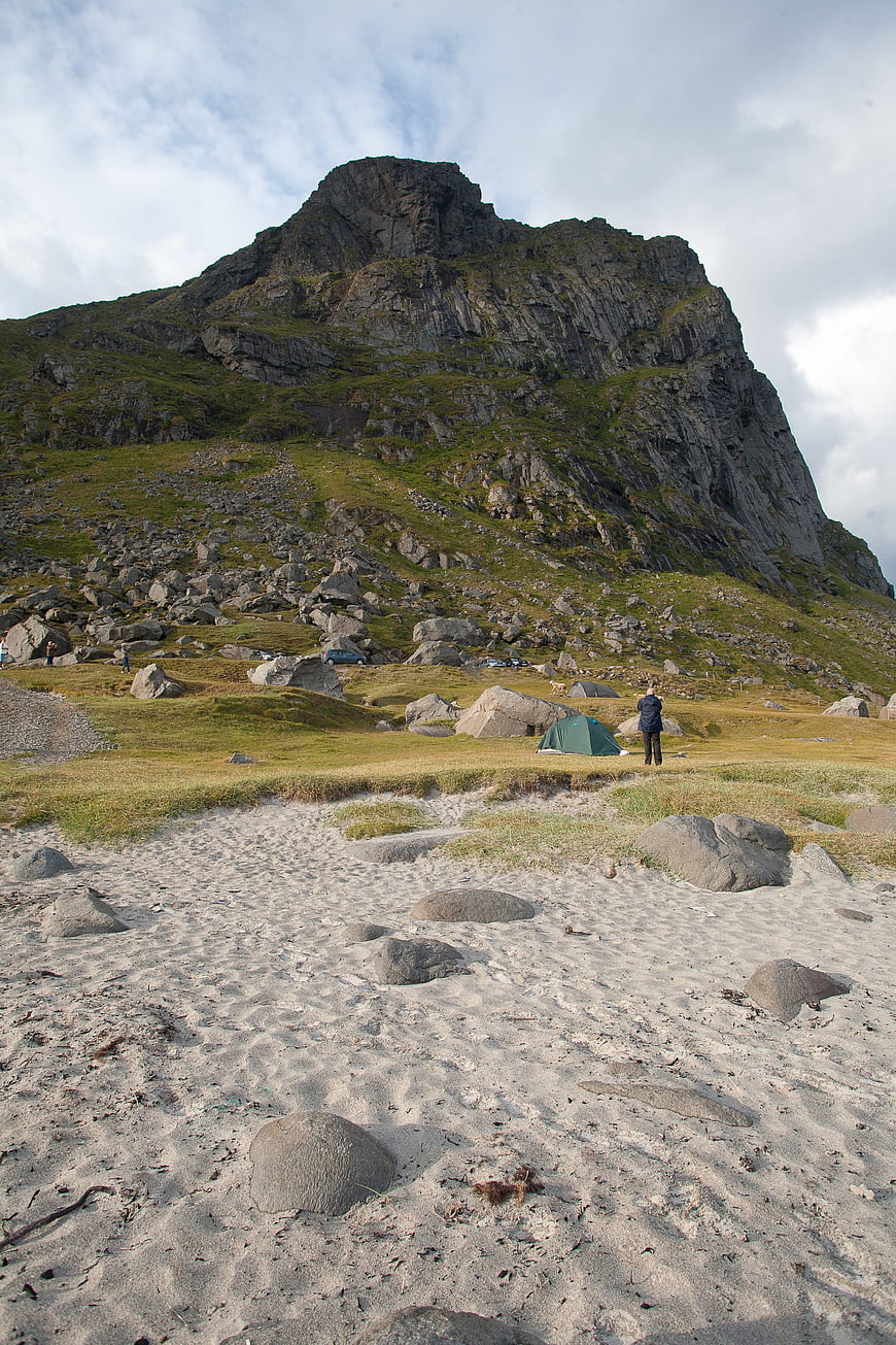 Camping on a sandy beach with a dramatic mountain backdrop in Lofoten, Norway