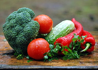 Fresh raw vegetables with water droplets on wooden board