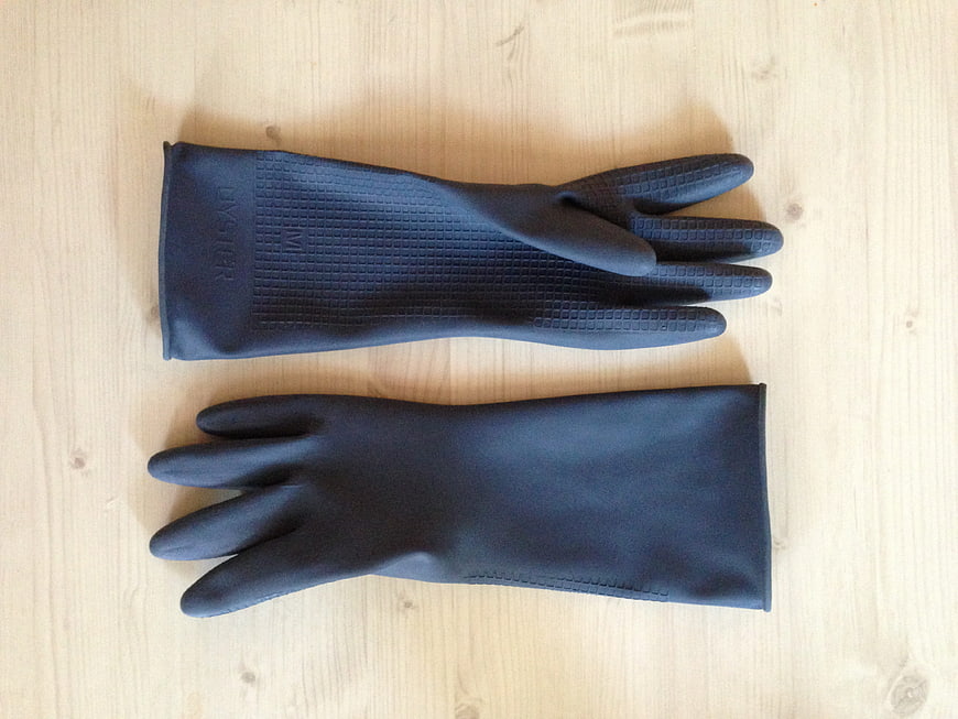 Black rubber cleaning gloves on wooden surface