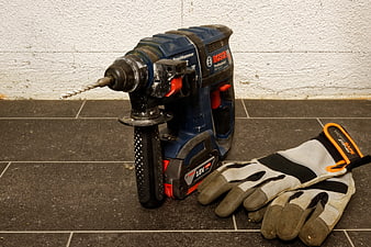 Bosch Cordless Rotary Hammer Drill and Work Gloves on Tile Floor