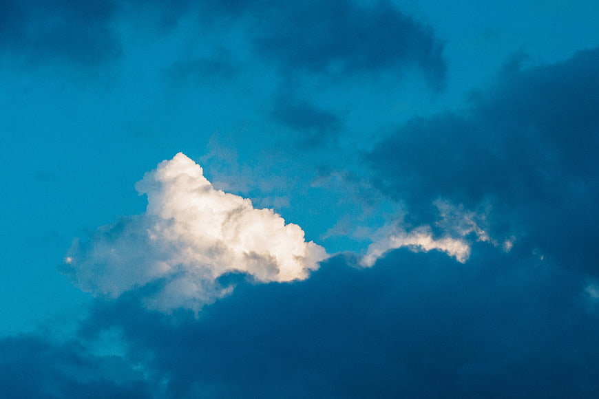 Dramatic white cloud against deep blue sky background
