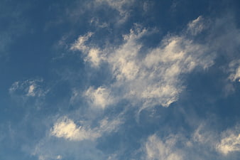 Fluffy white clouds against a deep blue sky background