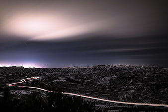 Long exposure night landscape with light trails on mountain road