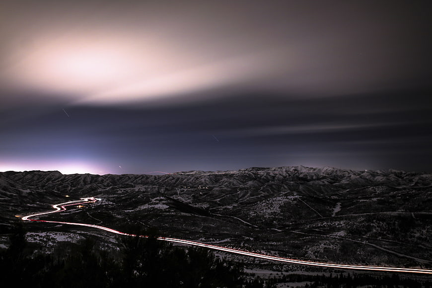 Long exposure night landscape with light trails on mountain road