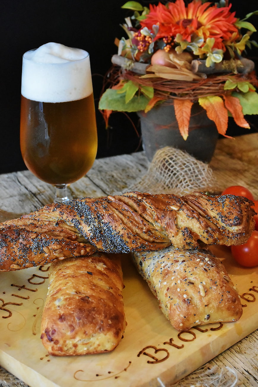 Artisan Bread Loaves and Beer on Wooden Board