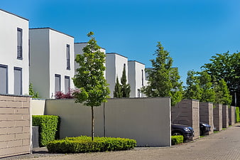 Modern white townhouses with minimalist architecture and blue sky
