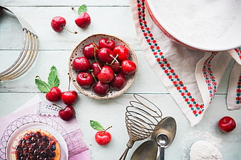 Top view of fresh cherries and baking ingredients on rustic table