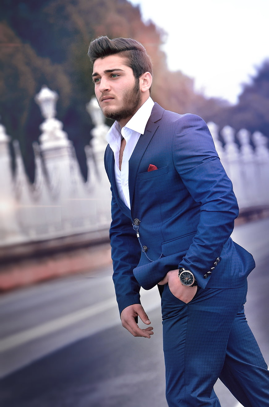 Young man in blue suit walking on a city street