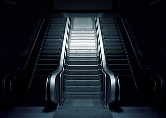 Dark Symmetrical Subway Staircase Between Escalators