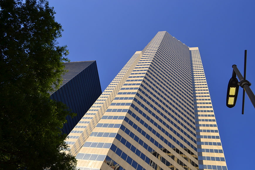 Low angle view of modern glass skyscraper against clear blue sky
