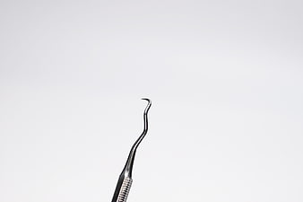 Minimalist Dental Curette Tool On White Background