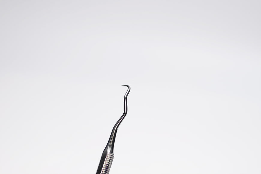 Minimalist Dental Curette Tool On White Background