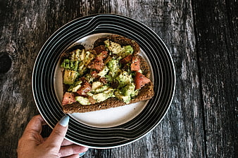 Avocado Toast on Striped Plate Over Dark Wood