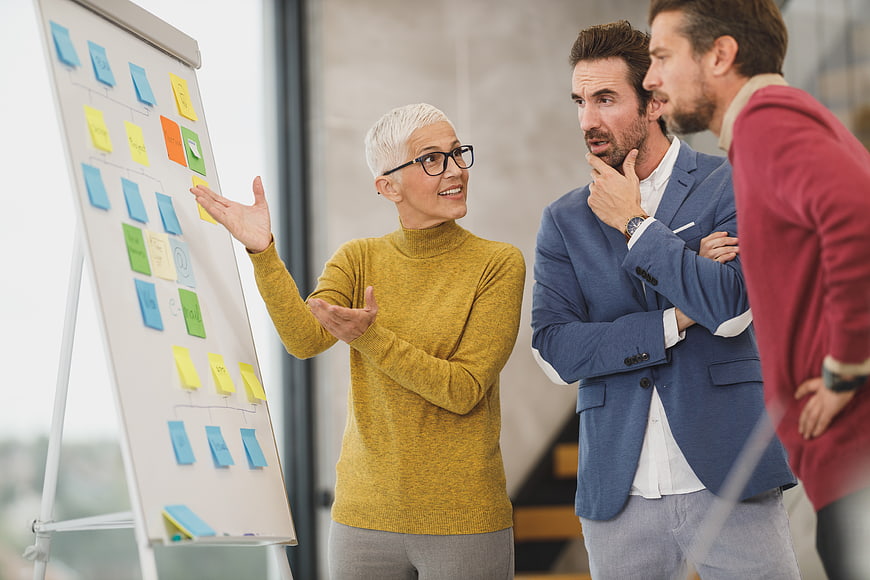 Senior woman presenting strategy to colleagues in office