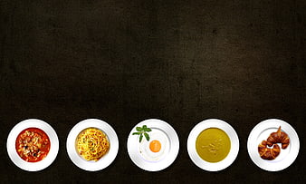 Top view of five white plates with different food dishes on dark background