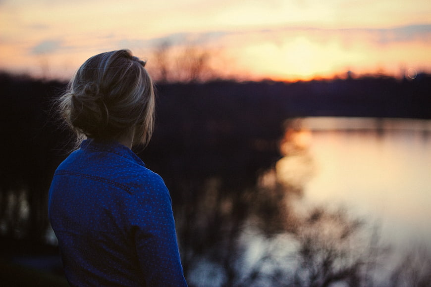 Woman Watching Sunset Over Lake