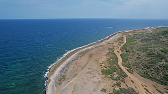 Aerial View of Rugged Coastal Cliff and Blue Ocean