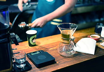 Barista preparing pour-over coffee on wooden counter