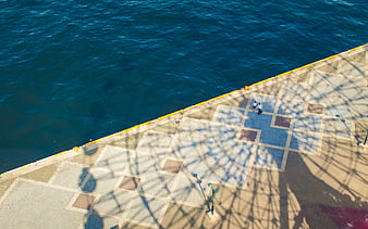 Aerial view of two people walking on a geometric pier
