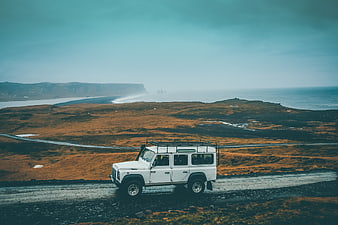 White SUV on Coastal Road with Ocean View