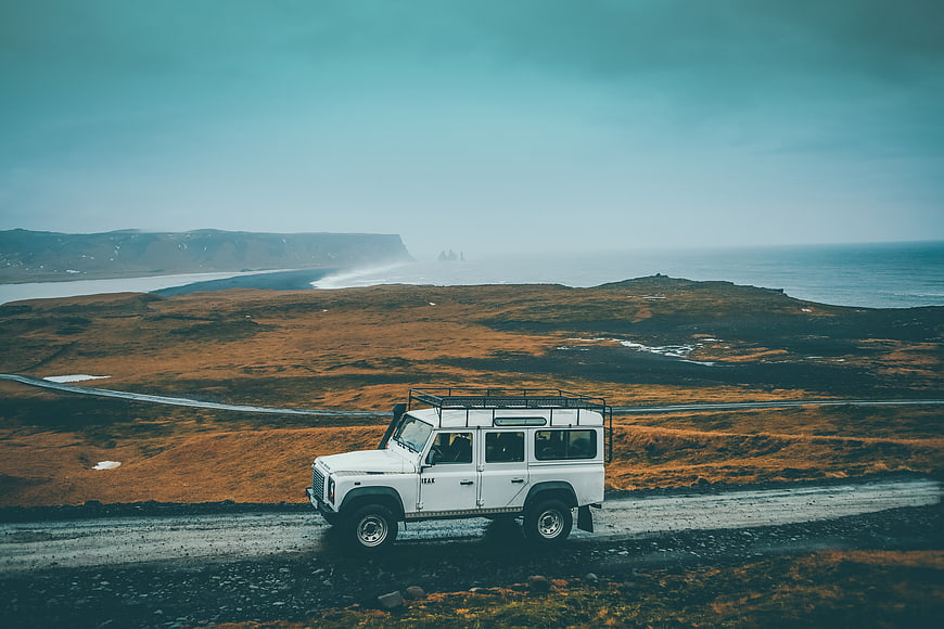 White SUV on Coastal Road with Ocean View