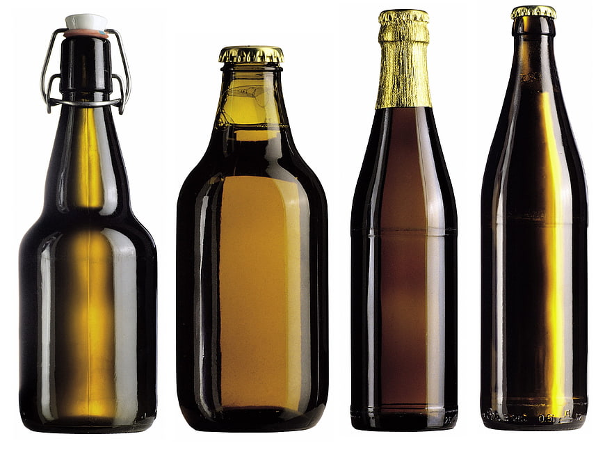 Four different brown glass beer bottles on white background