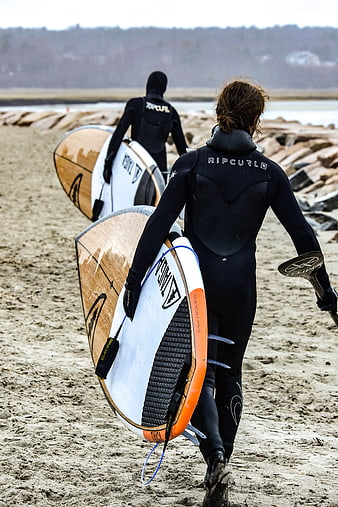 Surfers in Wetsuits Walking on Sandy Beach with Boards